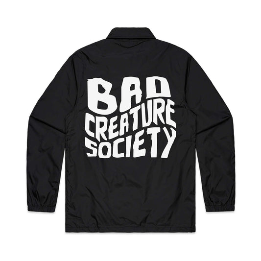 Black coach jacket with 'Bad Creature Society' text on the back against a white background